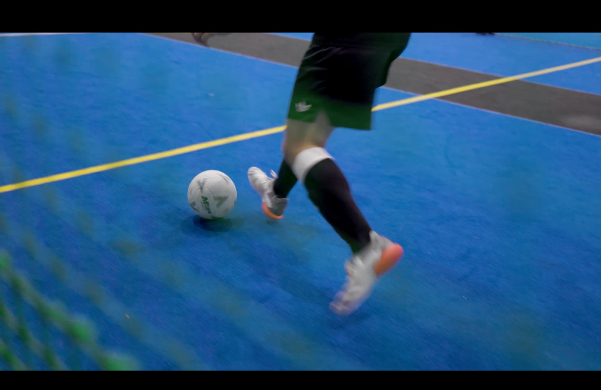 Indoor soccer action viewed through the net