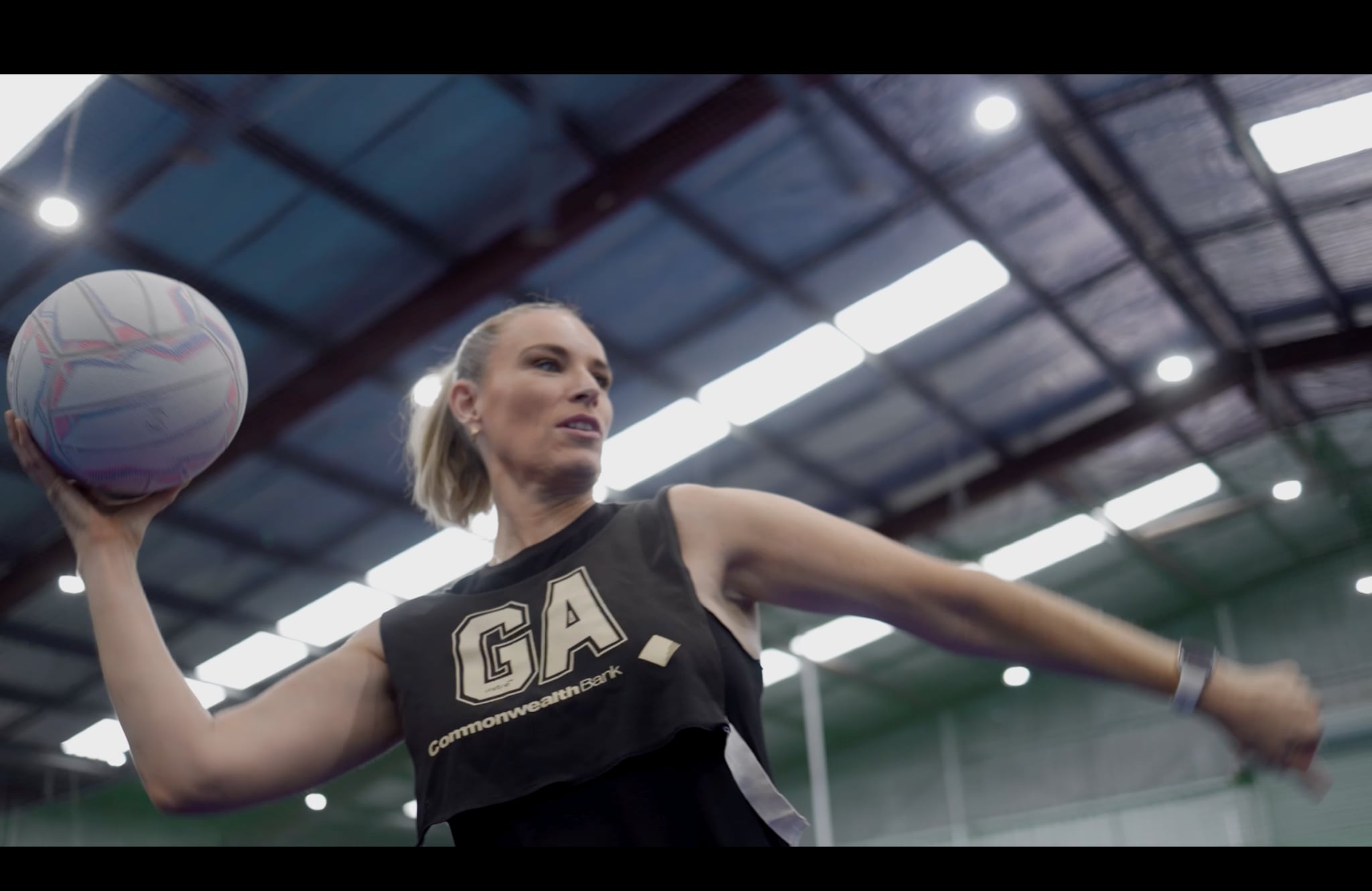 Netball player in GA bib ready to shoot